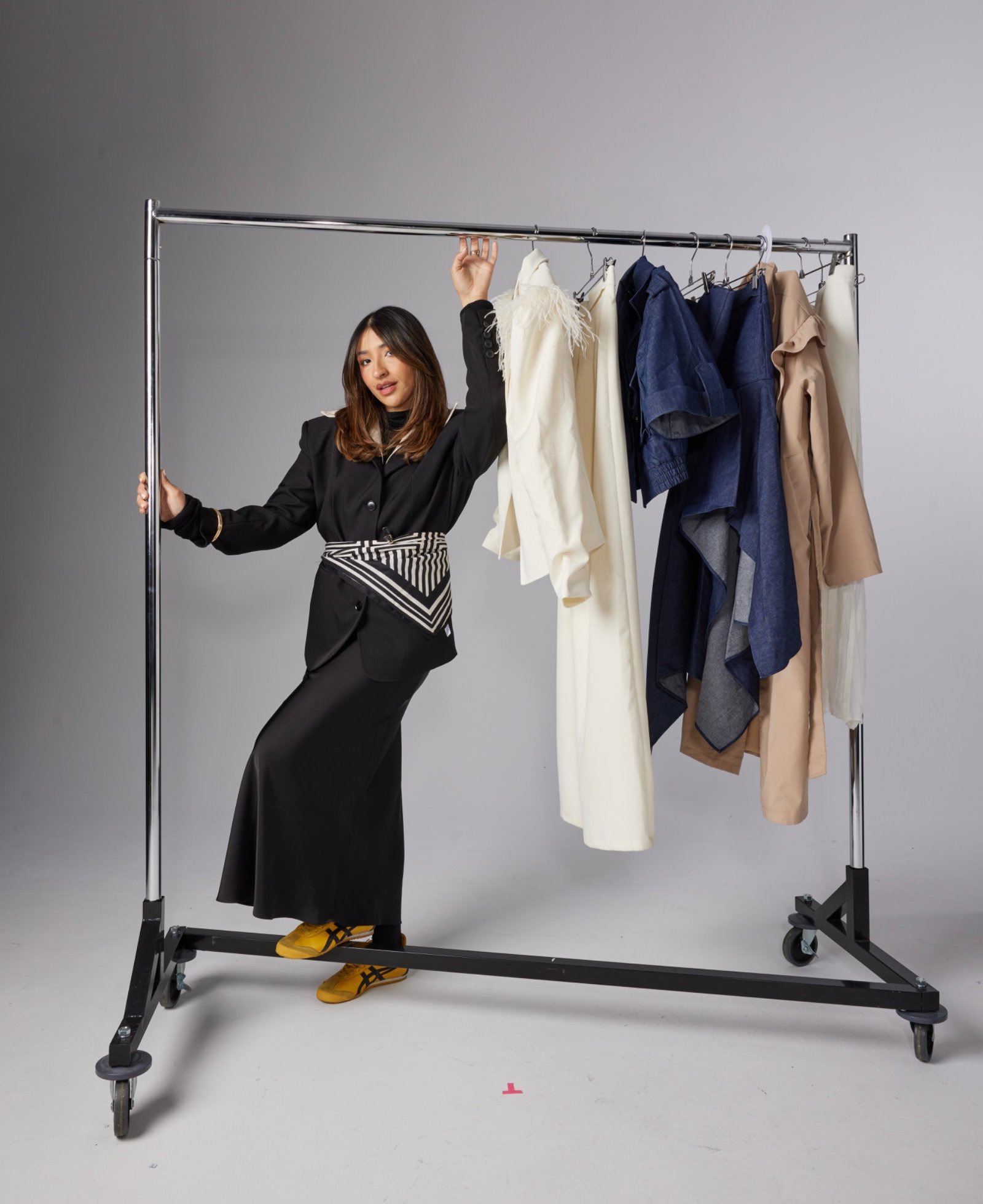 Allison López junto a un rack de ropa durante una sesión de styling