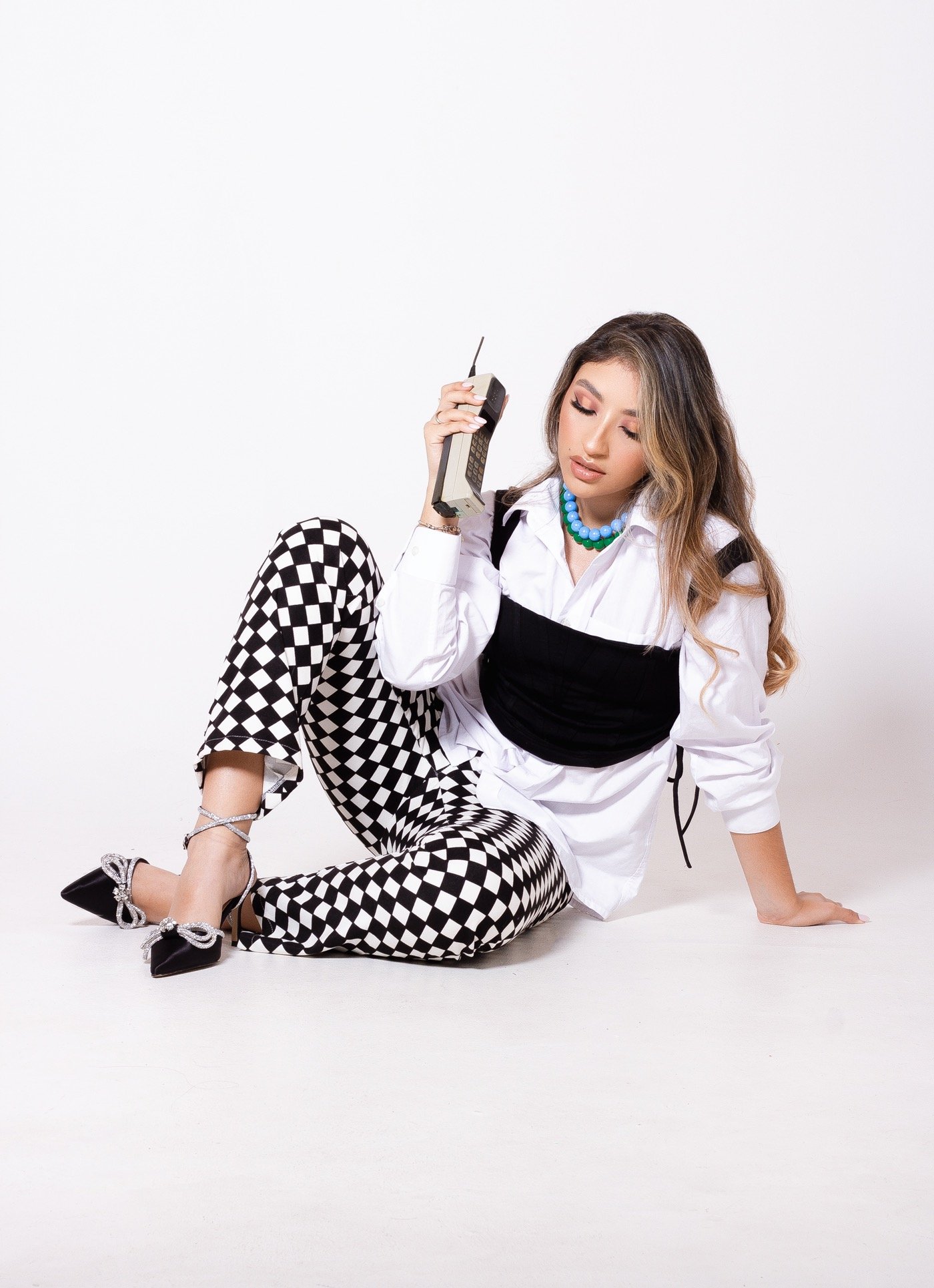 Allison López en una sesión de moda con pantalones de cuadros y teléfono retro